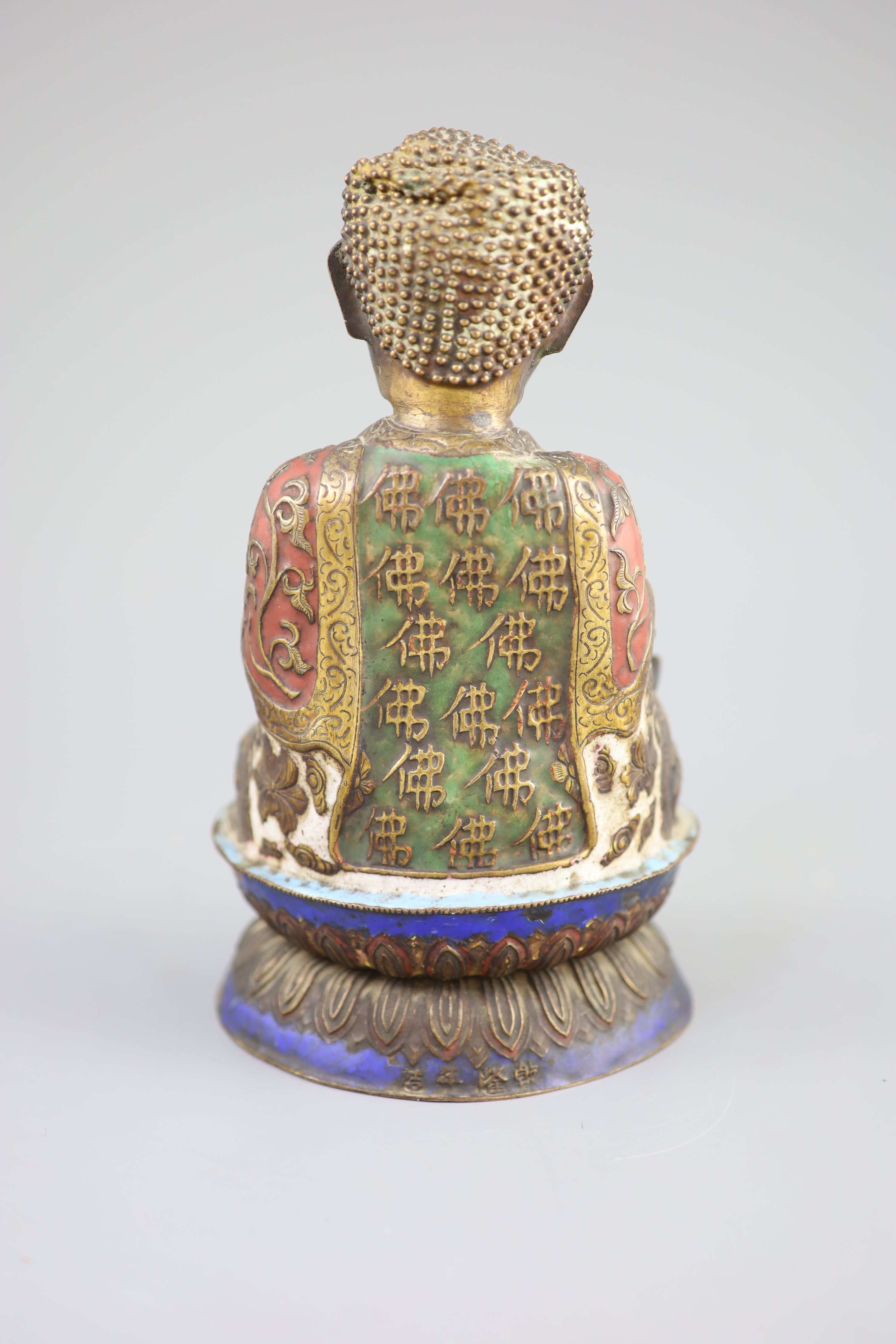 A Chinese copper alloy and enamel seated figure of Buddha Shakyamuni, Qing dynasty, 24cm high, faults